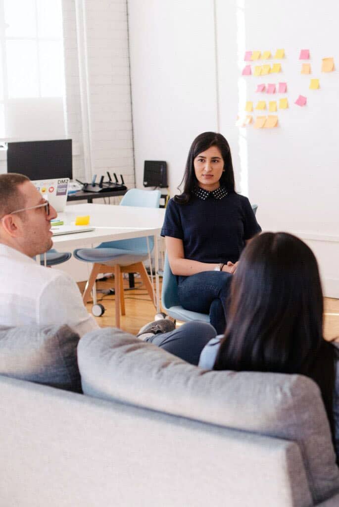 Office workers discussing the Google workspace training information provided by Encompass Innovate in their modern office.