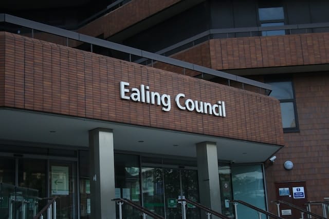 Exterior image of Ealing council office building in the UK with white text sign on the bricks
